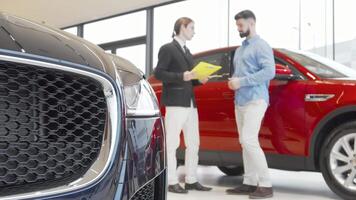 Male customer and salesman sealing the deal with a handshake at a car dealership video