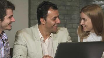 Dynamic team of business professionals laughing and collaborating at the office video