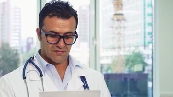 Doctor in glasses gives a thumbs-up while examining a document video