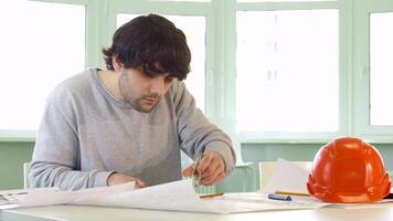 Caucasian architect confidently using a compass at his workspace video