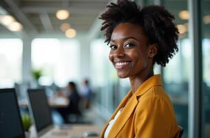 Confident professional woman smiling at modern office desk in bright open workspace. international workers day photo