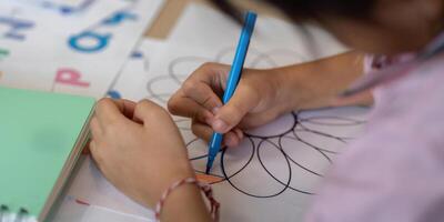 Focus and Creativity. A child drawing intricate patterns on paper. photo