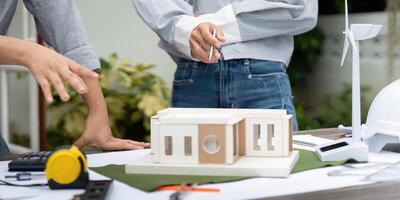 Sustainability and Architectural Model. Professionals discussing a sustainable building model with renewable energy features. photo