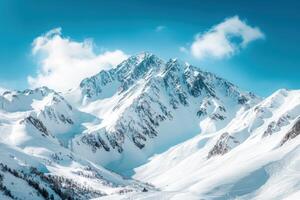 Snow-capped mountain peak under a blue sky with clouds photo