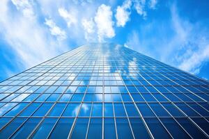 Glass Facade of a Skyscraper Reflecting Clouds and Blue Sky photo