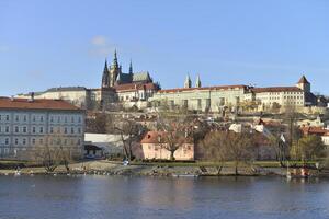 A city with a castle and a river in the foreground photo