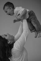 Young mother with her two year old son, dressed in the same style, relaxing and playing together. photo