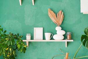 white small frame on shelf with decoration objects, rustic green wall photo