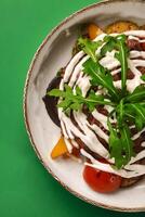 Grilled beef steak with vegetables and yogurt sauce on green background photo