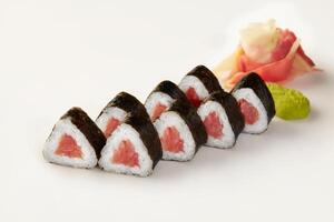 Triangular sushi pieces with tuna filling, wasabi, and ginger on white background photo