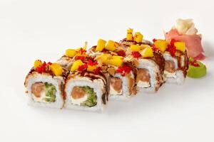 Delicious sushi rolls with mango, salmon, and red tobiko on white background photo