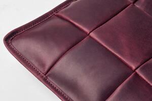 Burgundy leather surface showing stitching and square pattern photo