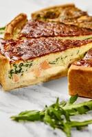 Delicious homemade salmon and spinach quiche resting on a marble surface photo