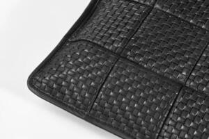 Corner of black leather woven placemat showing intricate detailing photo