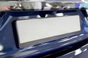 A close up of a blue car with a license plate photo