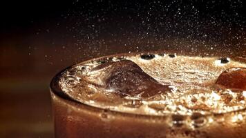 A glass of cola with ice. Splashes on the surface. Filmed on a high-speed camera at 1000 fps. High quality FullHD footage video