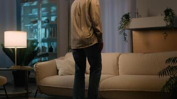 Tired ethnic girl African American woman homeowner come in evening living room falling on cozy comfortable sofa relaxing after working day lying on couch weekend leisure relax at own home night sleep video