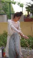 A Girl Joyfully Twirling Fairy Lights in a Beautiful and Enchanting Garden Setting video