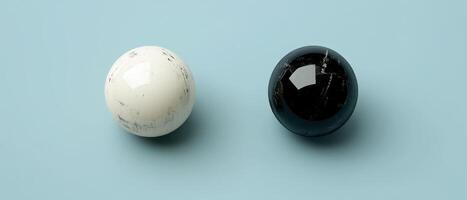 Yin and Yang concept with black and white spheres on a light blue background, representing balance, harmony, and duality photo