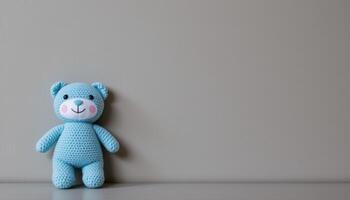 Gray background with blue plush toy and copy space, baby boy announcement or birthday party concept photo