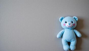 Gray vertical background with blue plush toy and empty space, baby boy birth concept vertical layout photo
