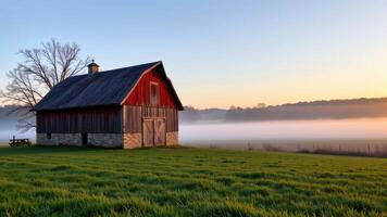 a rustic barn at sunrise, morning fog rolling off fields. photo