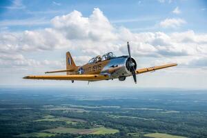 A vintage airplane flying in the sky with a propeller and a view of the landscape below it photo