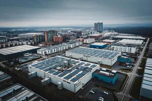 Aerial view of an industrial area with buildings, solar panels, and a cityscape under a cloudy sky photo