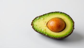 Close up of ripe avocado with sparkling water droplets, resting on clean white background photo