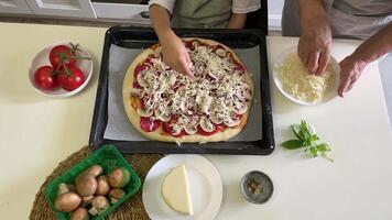 Grandmother and grandchild adding cheese to pizza video