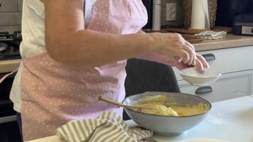 Baker whisking and adding ingredients to dough in a bowl video