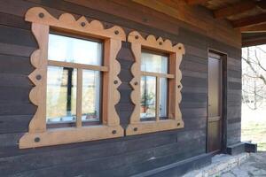 Charming Rustic Wooden Cabin Featuring Beautifully Ornate Window Frames and Details photo