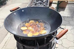 Frying Up Delicious and Crispy Potato Chips in a Wok Cooked Over an Open Flame for Everyone photo