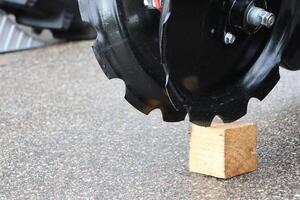 A Heavy Machinery Tire resting on a Wood Block designed for Elevated Support needs photo