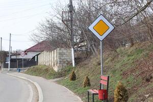 Tranquil and serene roadside scene featuring a bench next to a prominent yield sign photo