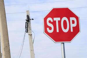 Stop Sign Located at Intersection where Power Lines Cross, Signifying Caution and Safety photo