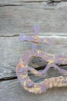 A Rusty Iron Cross and Chain Suspended on a TextureRich Piece of Weathered Wood Background photo