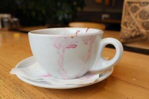 A Coffee Cup with Stains Placed on a Wooden Table Surface, Perfect for Afternoon Enjoyment photo