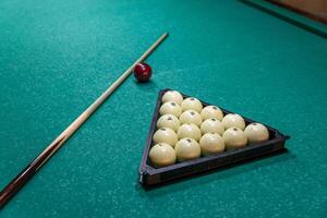 A pool table with balls and a stick photo