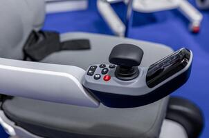A close up of a wheelchair with a controller photo