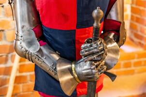 A man in a medieval armor holding a sword photo