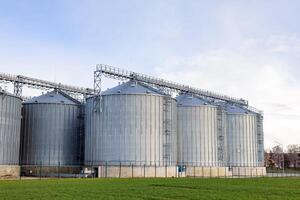 A large group of grain silos in a field photo