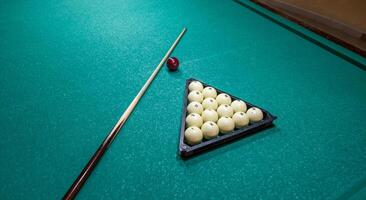 A billiard table with balls and a cue stick photo
