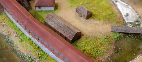 A model of a small town with a river and a bridge photo