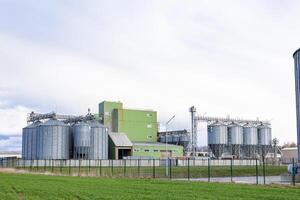 A large grain silo and a green building photo
