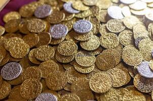 Gold coins are scattered on a table photo