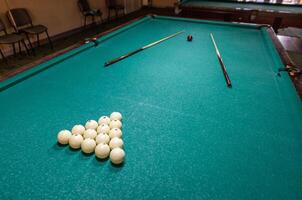 A pool table with balls and sticks photo