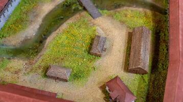 A model of a farm with a small river and a small house photo