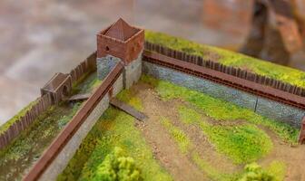 A model of a castle with a fence and a wall photo