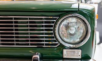 A close up of a green car with a front grill photo